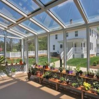 A sunlit indoor garden with potted plants under a glass ceiling.