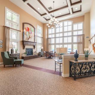 A spacious and elegantly designed lobby with large windows, comfortable seating, and tasteful decor.