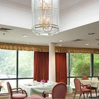 A well-lit dining area featuring elegant furnishings and large windows.