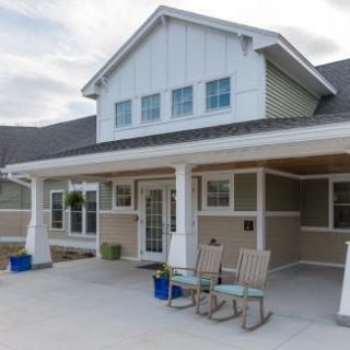 A modern house with a welcoming porch and outdoor seating.
