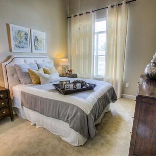 A cozy bedroom with elegant decor, featuring a comfortable bed and soft lighting.