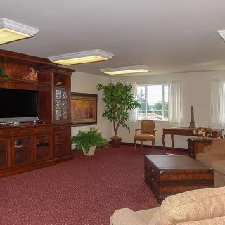 A spacious living room with a large television, comfortable seating, and natural light.
