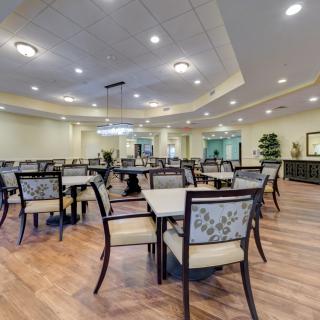 A spacious dining area with neatly arranged tables and chairs, featuring modern lighting and interior design.
