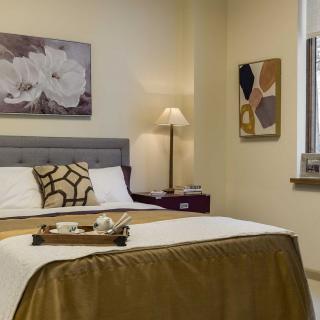 A cozy and well-decorated bedroom with stylish artwork and a neatly arranged bed.