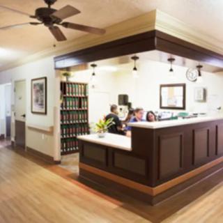 A cozy office reception area with a wooden desk and warm lighting.