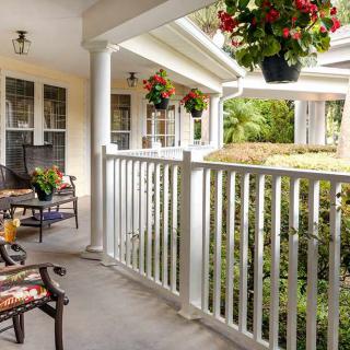 A cozy porch with rocking chairs and hanging plants.