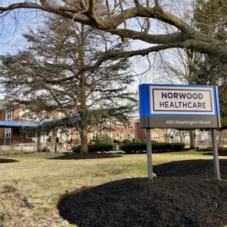 View of the Norwood Healthcare facility with a clear sign in front.