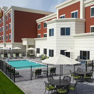 A modern hotel with an outdoor swimming pool and seating area.
