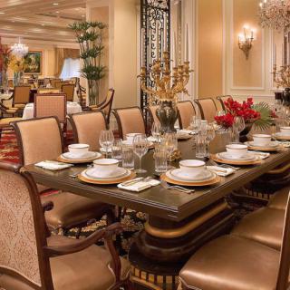 A luxurious dining room with an elegantly set table and plush seating.
