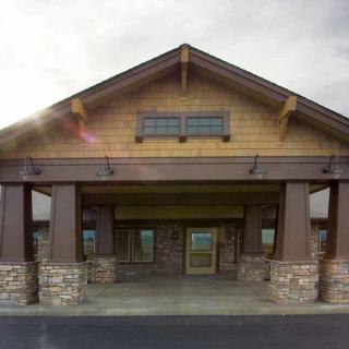 A building with a wooden and stone facade featuring a covered entrance.