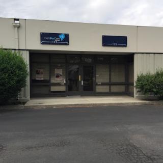 An exterior view of a commercial building with large windows and entrance doors.