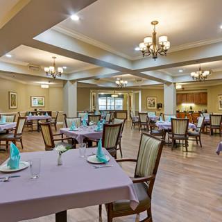 An elegant dining room with neatly arranged tables and chandeliers.