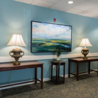 A decorated hallway with lamps and artwork on blue walls.