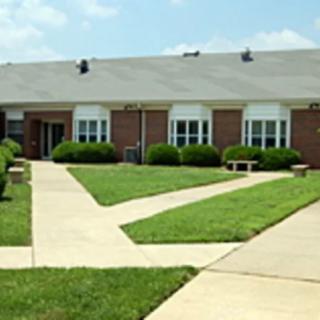 A suburban building with a neatly maintained lawn and intersecting pathways.