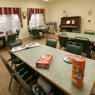 A cozy dining area featuring tables and chairs, a piano in the background, and snacks on display.