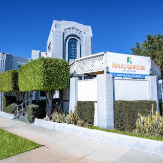A modern commercial building featuring a well-maintained exterior and neatly trimmed hedges.