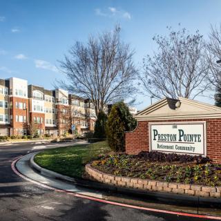 Entrance to a residential apartment complex with well-maintained landscaping.