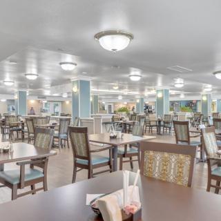 An elegant and spacious dining room with neatly arranged tables and chairs, ready for guests.