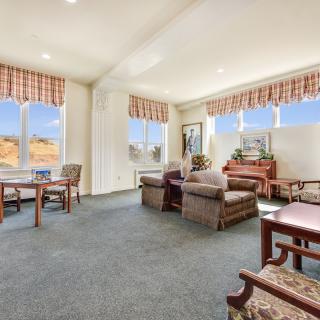 A spacious and well-lit living room featuring comfortable seating, large windows with scenic views, and a cozy atmosphere.