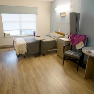 A clean and minimalist hospital patient room with two beds and natural light.