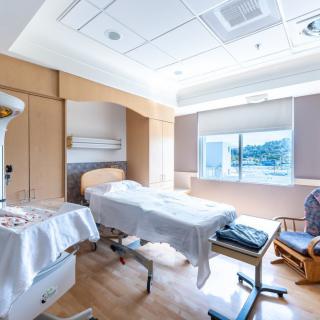 A clean and well-lit hospital room with a bed and medical equipment.