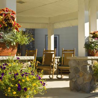 A cozy porch with rocking chairs and vibrant potted flowers.