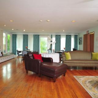 Spacious living room with modern decor, featuring hardwood floors and comfortable seating.