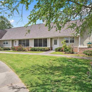 A suburban house with a well-maintained lawn and driveway on a sunny day.