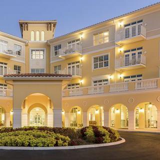 A modern, illuminated residential building at dusk.