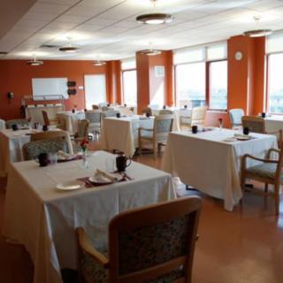A spacious dining room with neatly arranged tables and chairs.