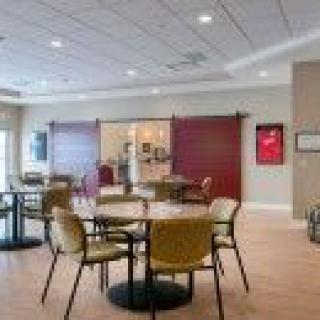 A modern dining area with tables and chairs, featuring stylish lighting and decor.