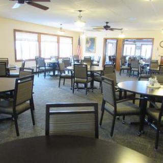 An empty dining room with tables and chairs arranged neatly.