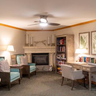 A cozy living room with a fireplace, bookshelves, and comfortable seating.