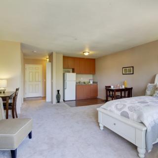 A cozy studio apartment featuring a kitchenette, bed, and dining area.