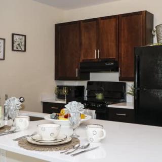 Modern kitchen with dark wood cabinets and a dining setup.