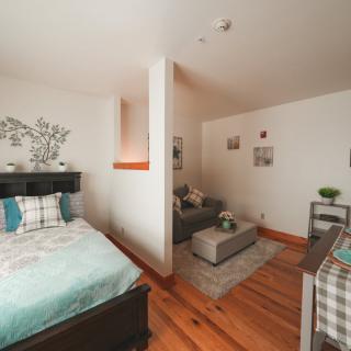 Cozy studio apartment with a bed and a small living area.