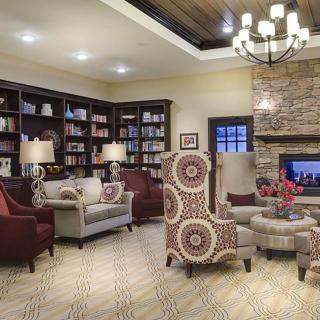 A cozy living room featuring a fireplace, comfortable seating, and built-in bookshelves.