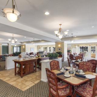 An elegant dining area with tables, chairs, and chandeliers providing a warm ambiance.