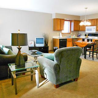 A cozy and modern living room with a view of the kitchen area.