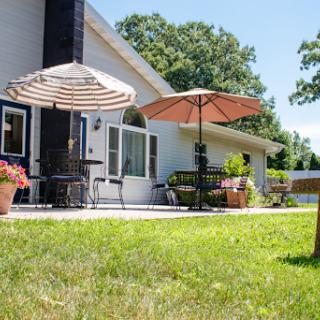 A sunny outdoor patio with umbrellas and a well-maintained lawn.