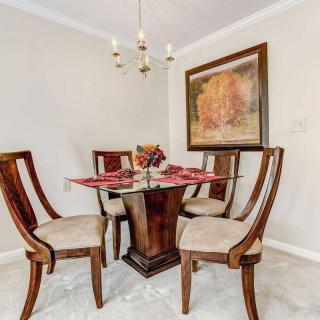 A cozy dining area with elegant wooden furniture and a decorative painting on the wall.