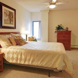 A cozy bedroom featuring a comfortable bed, elegant decor, and warm lighting.