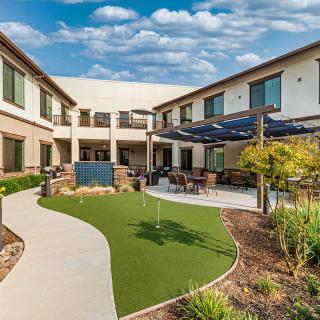 A beautifully landscaped courtyard with a patio area in a modern building complex.