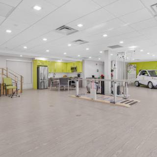 A spacious and modern gym interior featuring fitness equipment and bright green accents.