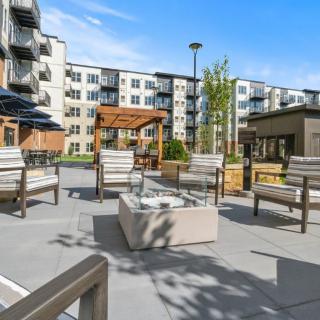 Modern apartment complex with outdoor seating and a fire pit area.