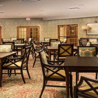 An elegant dining area with neatly arranged tables and chairs, featuring a warm and inviting atmosphere.