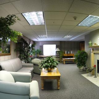 A cozy office space featuring comfortable seating and greenery.