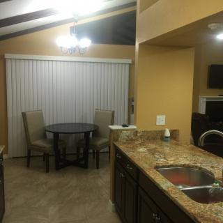 A cozy kitchen and dining area featuring granite countertops and a small round table with chairs.