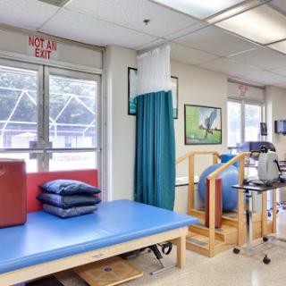 A well-equipped physical therapy room featuring exercise equipment and treatment areas.