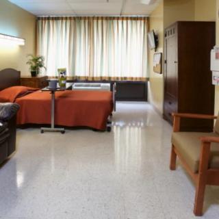 A tidy hospital room with two beds and basic amenities.